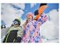 Dwoje uśmiechniętych dzieci ze snowboardami, w kurtkach narciarskich i czapkach, na tle gór.