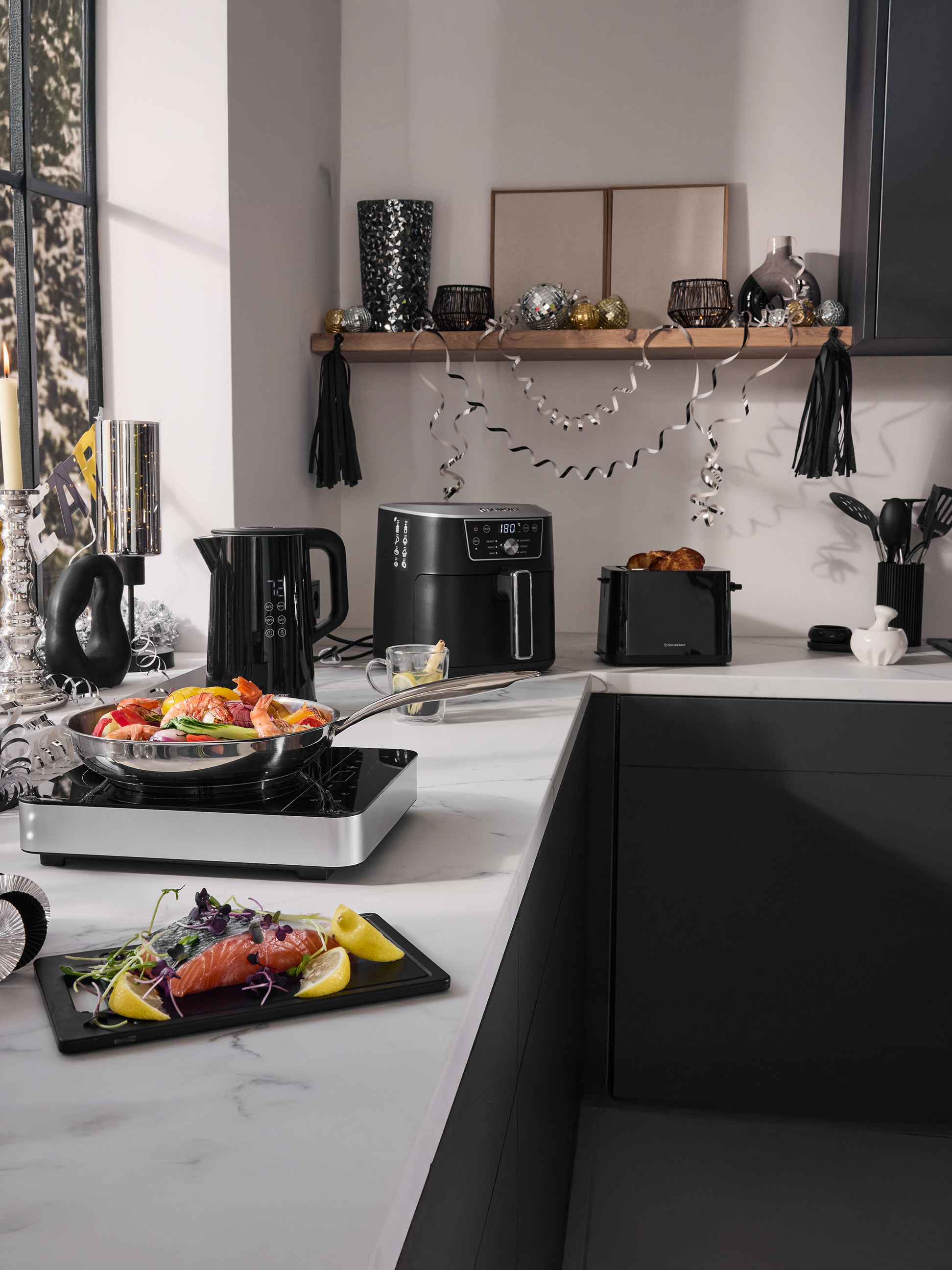 Blat kuchenny z frytkownicą beztłuszczową SilverCrest, czajnikiem, tosterem i akcesoriami kuchennymi, świątecznie udekorowany.