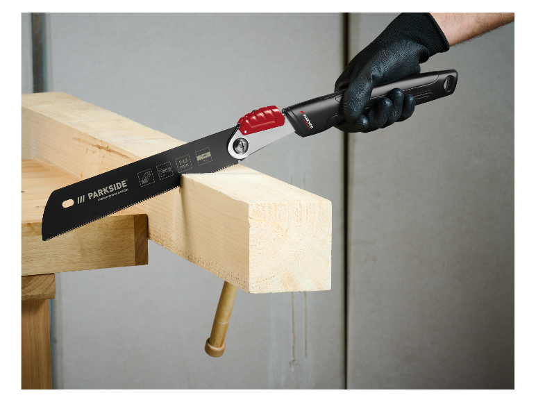 Mężczyzna używa piły Parkside do cięcia drewna.