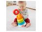 Dziecko bawi się kolorową wieżą z kółek Fisher-Price na białym dywanie.