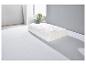 Biała poduszka z pikowanym pokrowcem na białym łóżku.