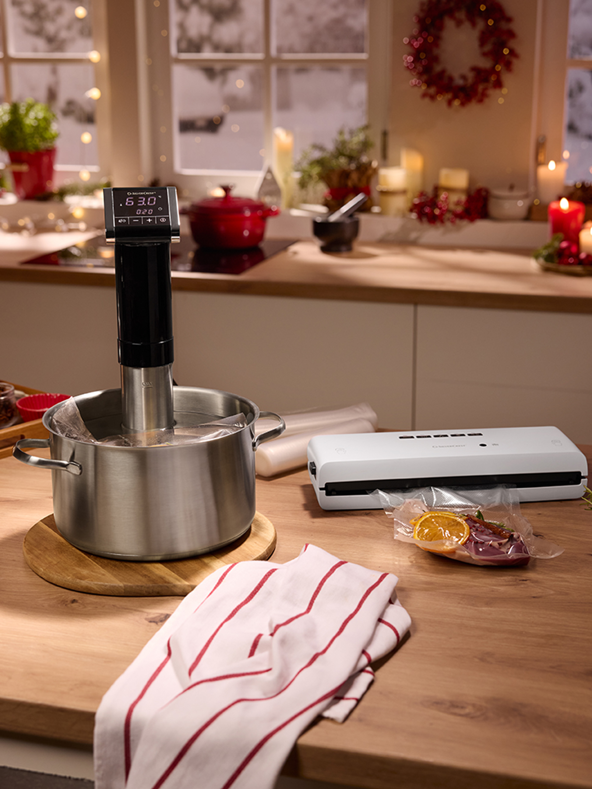 Urządzenie sous vide i zgrzewarka próżniowa na blacie kuchennym z świątecznymi dekoracjami.