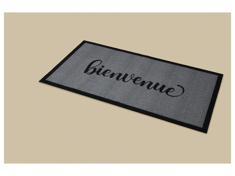Szara wycieraczka z napisem „bienvenue” (witaj) czarną kursywą.