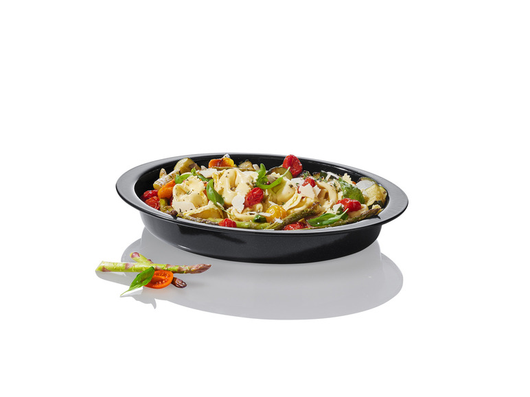 Tortellini z warzywami w czarnej formie do pieczenia.