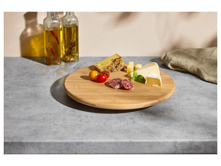 Deska do serwowania z serem, salami, pomidorkami koktajlowymi i oliwą.