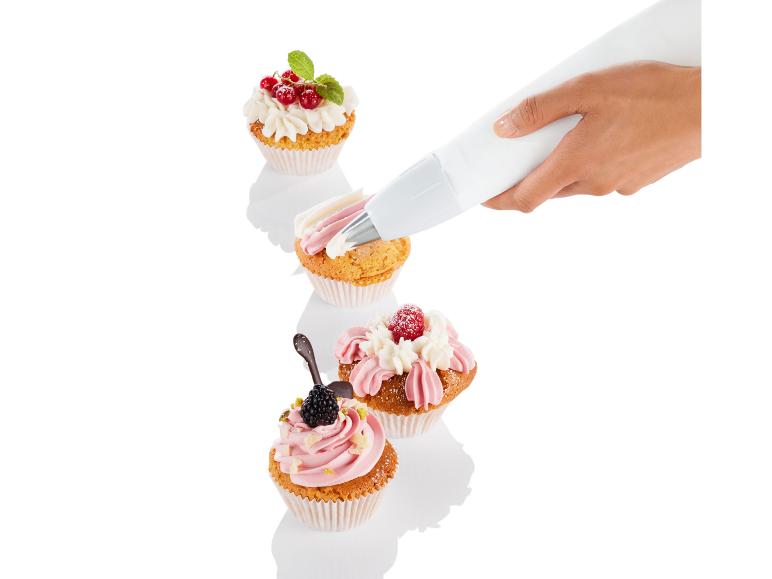 Ręka dekorująca muffiny kremem z ozdobnego woreczka
