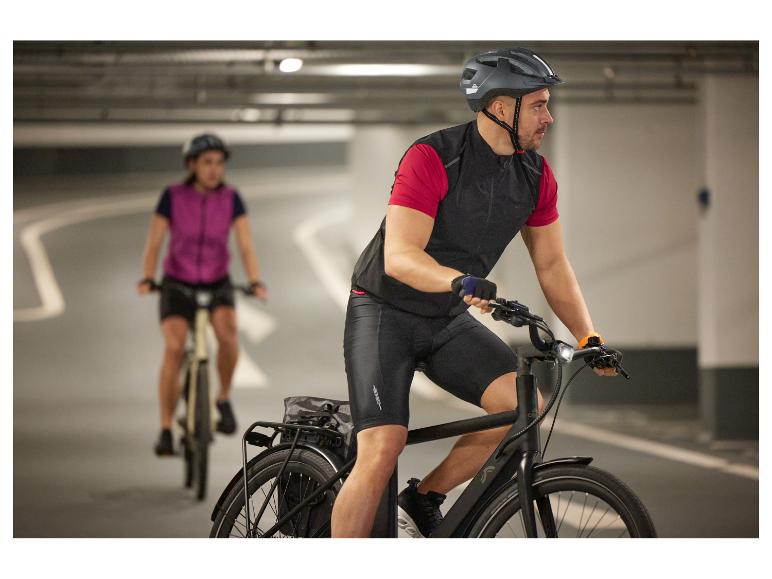 Dwie osoby jadące na rowerach elektrycznych, jedna w kasku.