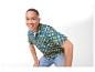 Mężczyzna w niebieskiej koszuli z żółtymi logo, uśmiechnięty do kamery.