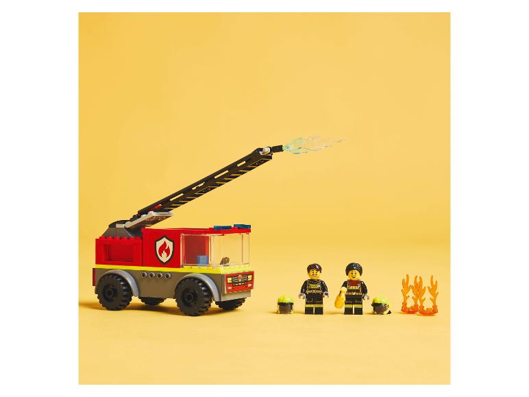 Wóz strażacki i minifigurki LEGO z akcesoriami na żółtym tle.