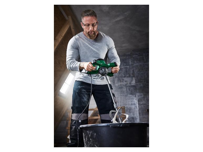 Mężczyzna używa elektrycznej mieszarki do mieszania zaprawy.
