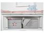 Biały przewijak z różową poduszką i niebieskim pluszowym misiem, oraz szarymi pojemnikami.