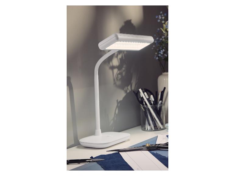Biała lampka biurkowa LED LIVARNO home na stole roboczym.