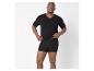 Mężczyzna w czarnym podkoszulku z dekoltem w serek i czarnych bokserkach.