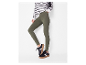 Modelka ma na sobie oliwkowe legginsy i czarne buty sportowe.