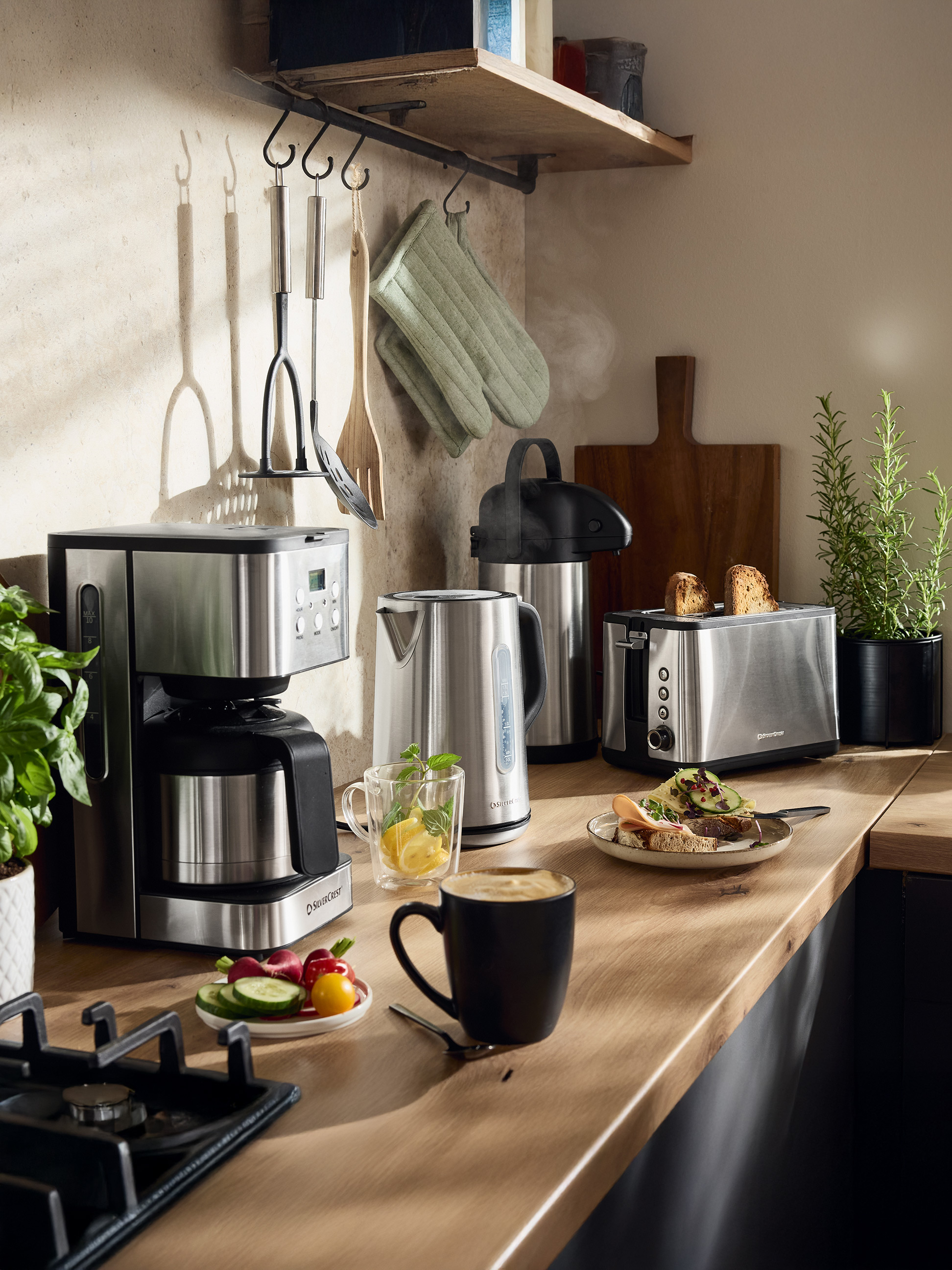 Ekspres do kawy SilverCrest, czajnik i toster w kuchni z jedzeniem i napojami.