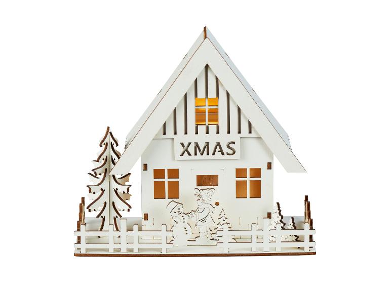 Dekoracyjny drewniany domek ze światłami, napisem „XMAS”, choinkami i zimowymi figurkami.