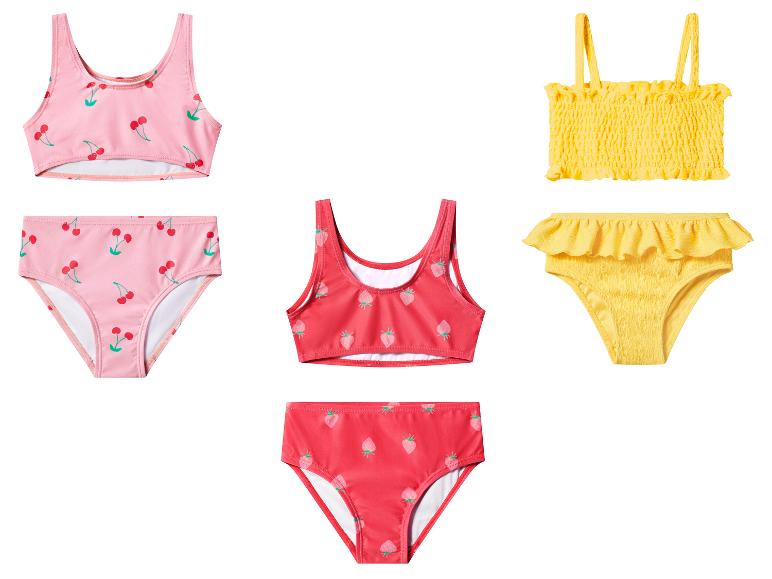 Dziecięce zestawy bikini: różowy w wiśnie, czerwony w truskawki i żółty z falbankami.