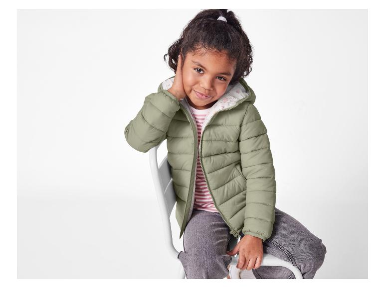 Dziewczynka w oliwkowej puchowej kurtce.