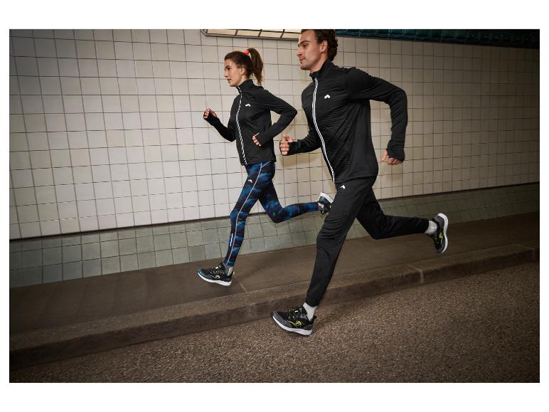 Dwóch biegaczy w czarno-niebieskich strojach sportowych, w tunelu.