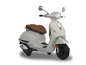 Biały skuter Vespa z brązowym skórzanym siedzeniem.
