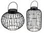 Dwie czarne metalowe dekoracyjne latarnie solarne, jedna kulista i jedna cylindryczna.