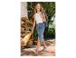 Kobieta w denimowej spódnicy z siateczką pełną owoców.