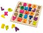 Drewniane puzzle z kolorowymi literami alfabetu, niektóre poza planszą.