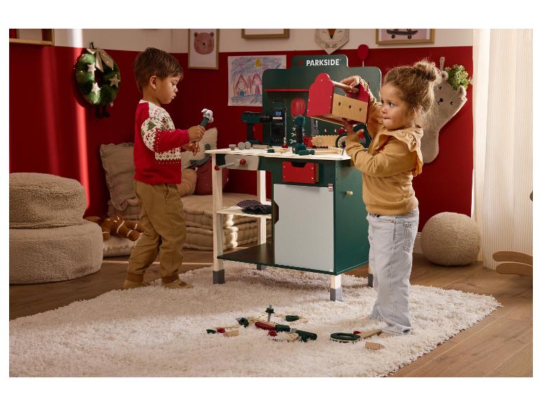 Dwoje dzieci bawi się zabawką stołem warsztatowym Parkside i narzędziami.