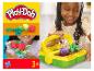 Zestaw Play-Doh do uprawy kwiatów z koszykiem, pokazany z uśmiechniętym dzieckiem.