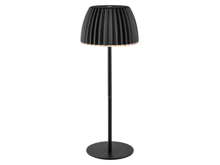 Czarna lampa podłogowa z plisowanym kloszem, emitująca ciepłe światło.