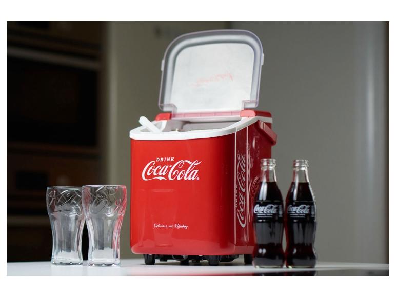 Czerwona lodówka Coca-Cola z dwiema butelkami Coca-Coli i dwoma szklankami.