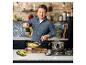 Jamie Oliver gotujący makaron w kuchni z ceglanymi ścianami i marmurowymi blatami