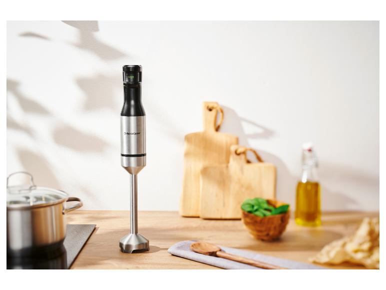 Blender ręczny SilverCrest na blacie kuchennym z garnkiem i przyborami kuchennymi.