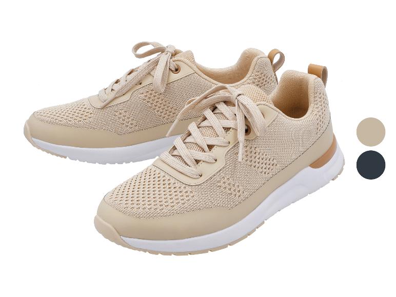 Dwa beżowe sneakersy ze sznurowadłami, białymi podeszwami i jasnobrązowymi detalami.