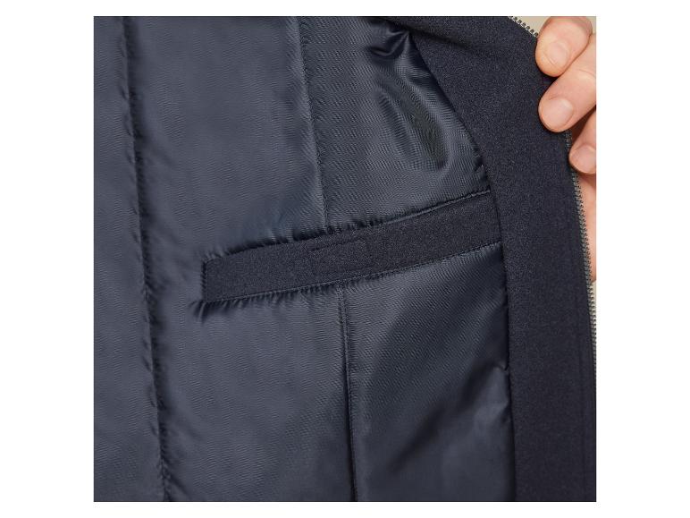 Wnętrze ciemnoniebieskiej kurtki z zamkiem błyskawicznym i kieszenią.