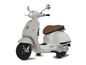 Biały skuter Vespa z brązowym siedzeniem.