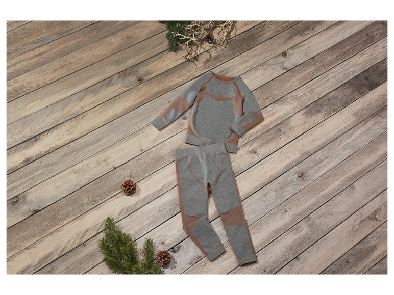 Szara bluza z długim rękawem i spodnie z pomarańczowymi detalami na drewnianym tle