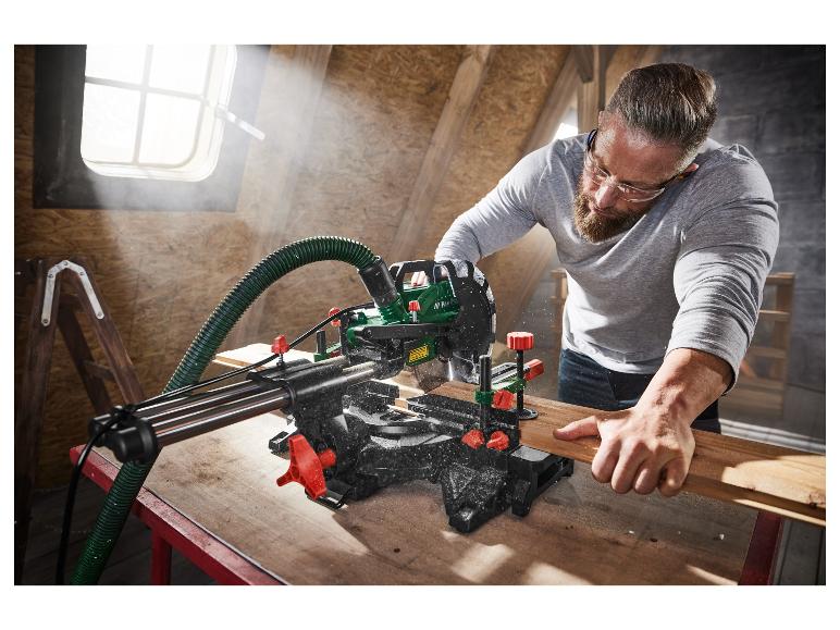 Mężczyzna używa piły ukośowej Parkside do cięcia drewna.