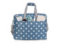 Niebieska torba w białe kropki z uchwytami, wypełniona akcesoriami do szycia.