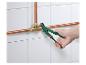 Hydraulik używa zielonych kluczy do łączenia miedzianych rur.