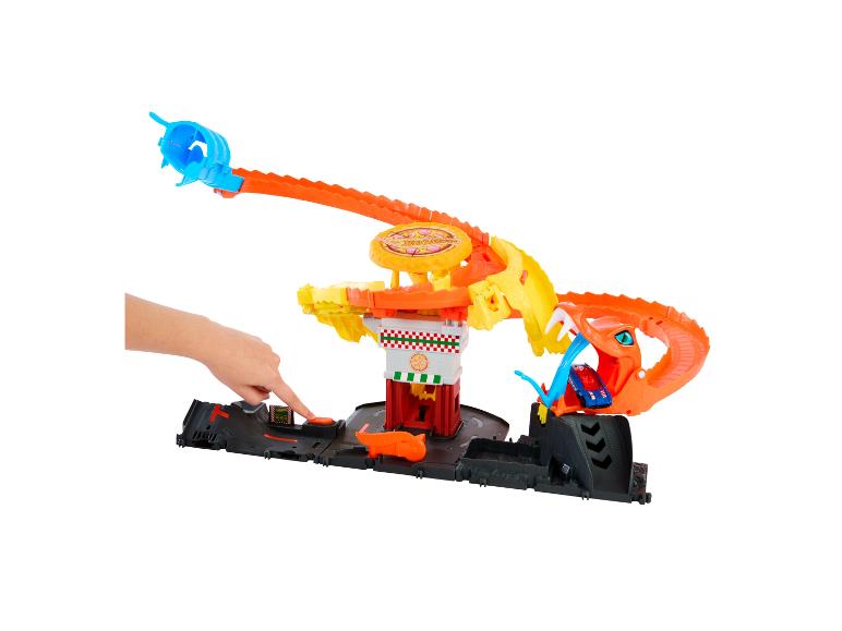 Tor Hot Wheels City Pizza z ręką naciskającą przycisk.