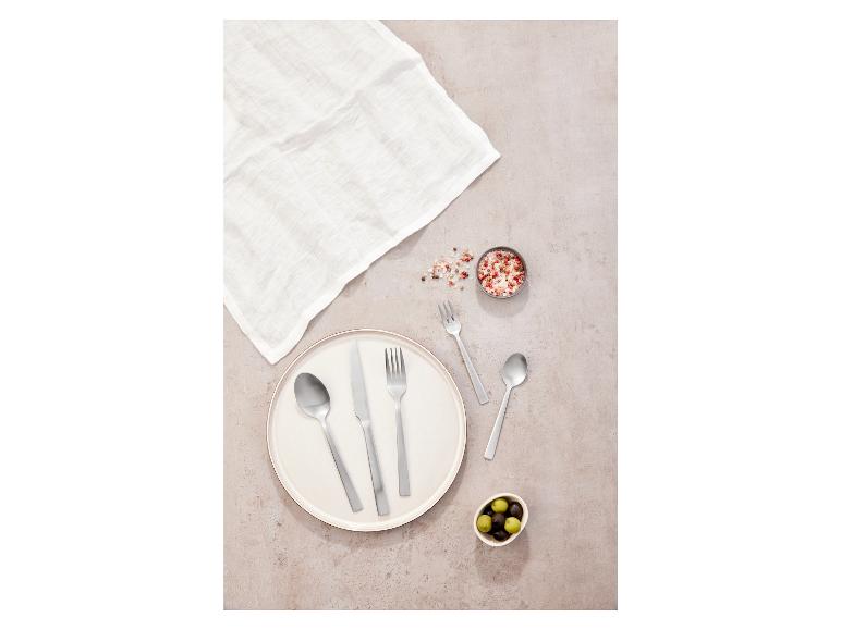 Zestaw sztućców, talerz i miseczka z oliwkami