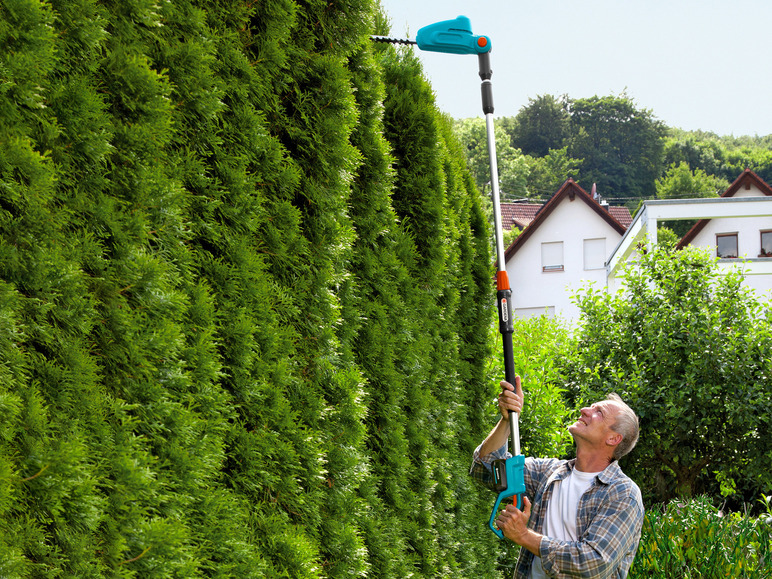 Mężczyzna przycina żywopłot za pomocą sekatora Gardena.