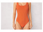 Pomarańczowy jednoczęściowy strój kąpielowy z okrągłym dekoltem.