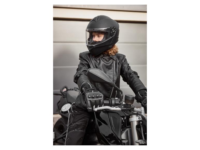 Kobieta w czarnym kasku motocyklowym, skórzanej kurtce i rękawicach na motocyklu