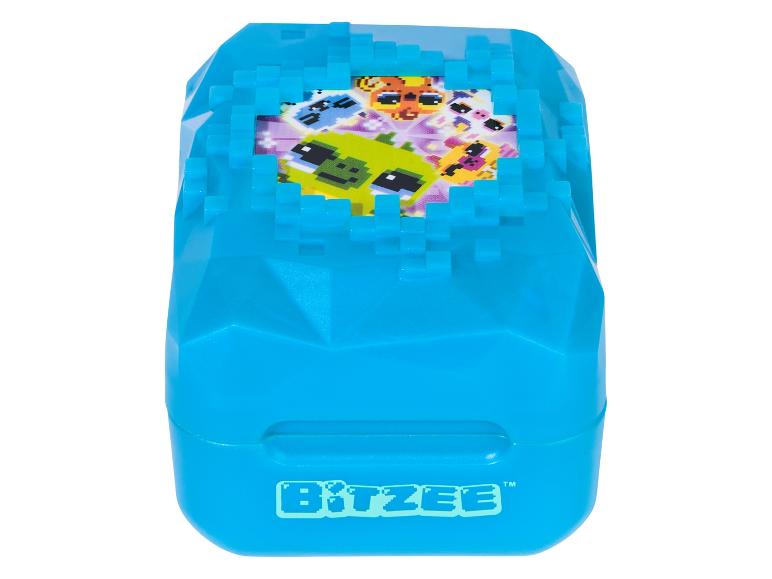 Niebieska zabawka Bitzee z pikselowymi stworzeniami na ekranie.