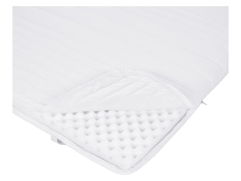 Biały materac z zamkiem błyskawicznym, odsłaniający wnętrze z pianki.