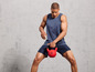 Mężczyzna w sportowym ubraniu z czerwoną kettlebell Crivit.