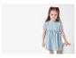 Dziewczynka w jasnoniebieskiej sukience dżinsowej.