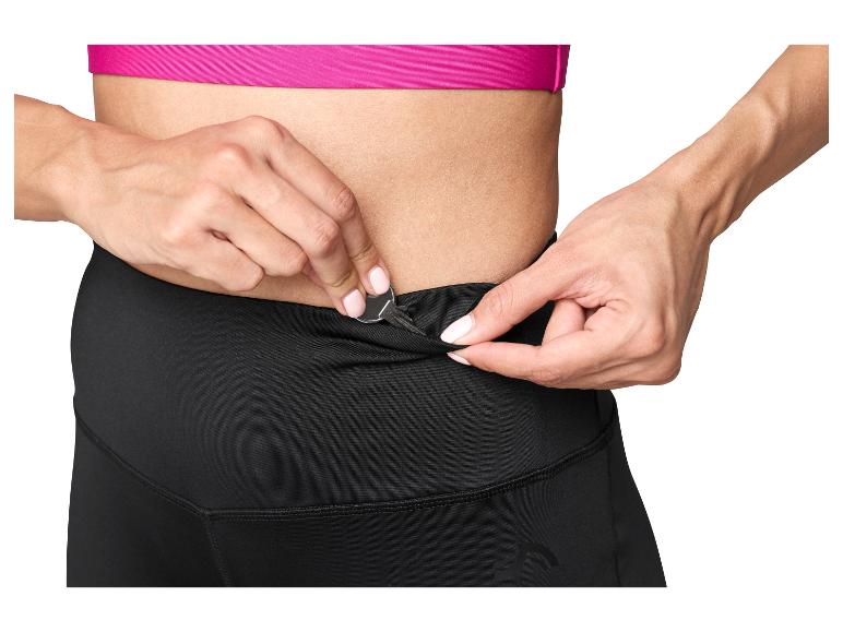 Kobieta wkłada klucz do kieszeni czarnych legginsów sportowych.